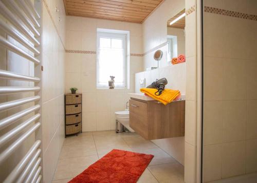 La salle de bains est pourvue de toilettes, d'un lavabo et d'une fenêtre. dans l'établissement Ferienwohnung Haus Edelweiss, à Winterberg