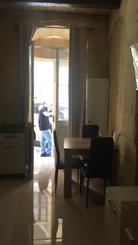 un homme debout dans une pièce avec une table dans l'établissement Valletta West Street Studio, à La Valette