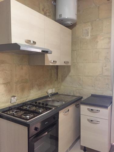 Il comprend une cuisine équipée d'une cuisinière et d'un évier. dans l'établissement Valletta West Street Studio, à La Valette