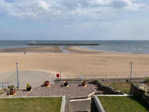 a view of a beach with a person standing on the beach at Bay View Apartment in Newbiggin-by-the-Sea
