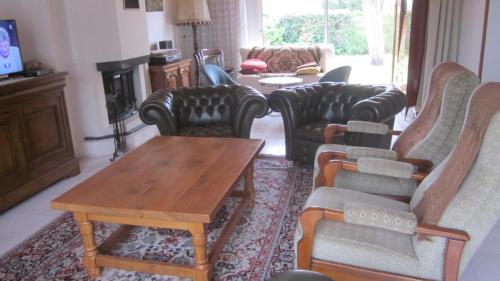 uma sala de estar com sofás e uma mesa de centro em Location La Brée les Bains 15 personnes em La Brée-les-Bains