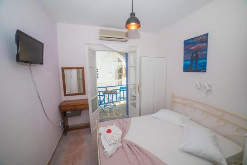 1 dormitorio con 1 cama, TV y mesa en Amorgaia 2, en Katápola