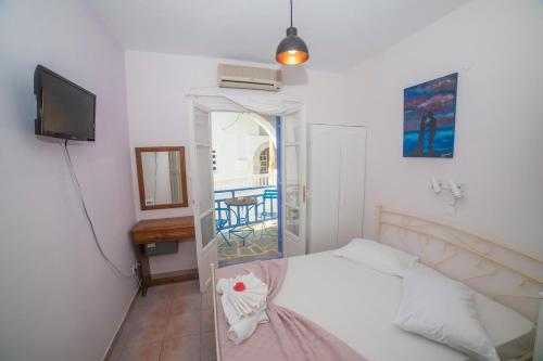 
a hotel room with a bed and a television at Amorgaia 2 in Katapola
