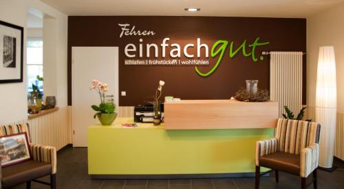 a lobby with a reception desk and two chairs at Fehren einfach gut in Lingen