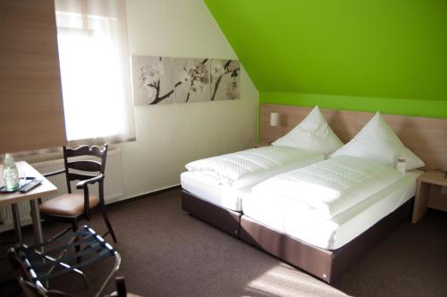 a bedroom with a bed and a table and a window at Fehren einfach gut in Lingen