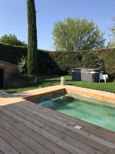 una piscina in un giardino con terrazza in legno di Guest House Olivades a Cassis