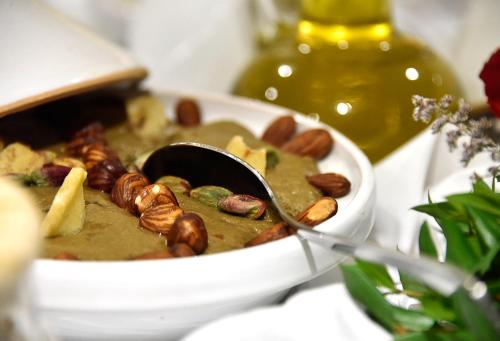 a bowl of soup with nuts and a spoon at BUSINESS HOTEL SFAX in Sfax