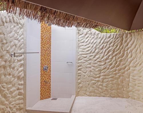 a white toilet sitting in a bathroom next to a wall at Adaaran Select Huduran Fushi - Premium All Inclusive in North Male Atoll