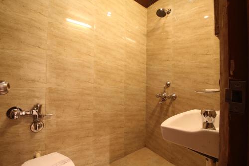 a bathroom with a toilet and a sink at Hotel Shivkrupa in Pune