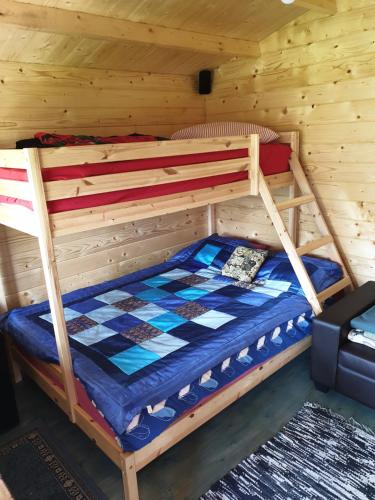 a bunk bed in a log cabin with a checkered floor at Cozy Summer House with Free Parking near City Center & Beach in Kuressaare