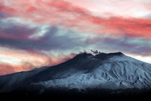 a mountain covered in snow under a cloudy sky at Hotel Villa Ducale in Taormina