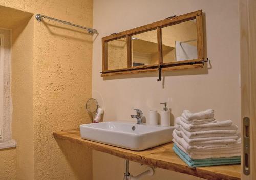a bathroom with a sink and a mirror and towels at Vila na Kamenu in Dobrinj