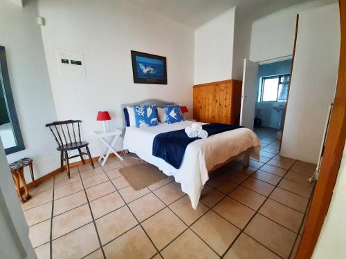 a bedroom with a bed and a chair in it at Oom Piet Accommodation in Gansbaai
