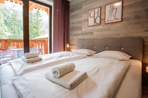 a bedroom with a large white bed with towels on it at Chopok Juh - Ambiente Apartment in Tale
