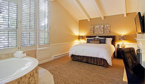 a bedroom with a bed and a bath tub at Carriage House Inn in Carmel