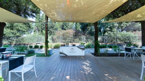 a pavilion with tables and white chairs and a sign at Hotel del Sole in Pompei