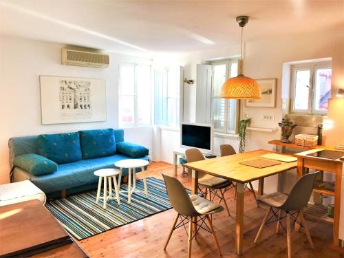 uma sala de estar com um sofá azul e uma mesa em Studio Doklestic em Dubrovnik