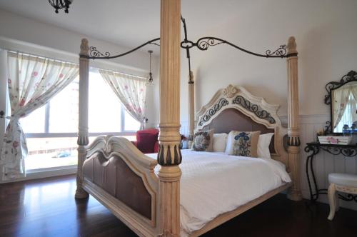 台東市的住宿－陽光滿屋民宿，一间卧室设有天蓬床和窗户。