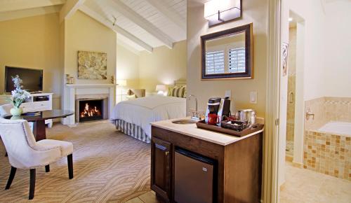 a hotel room with a bed and a fireplace at Carriage House Inn in Carmel