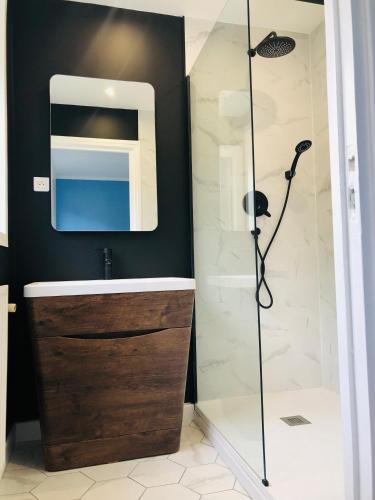une salle de bain avec une douche, un lavabo et un miroir dans l'établissement Face aux remparts, à Boulogne-sur-Mer