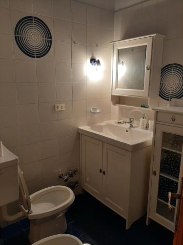 a bathroom with a white toilet and a sink at Le Chat Riant in Fenis