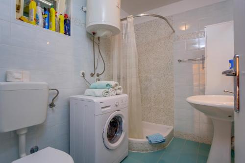 a bathroom with a washing machine and a sink at apartman Nataša in Mali Lošinj