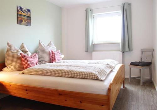 a bedroom with a wooden bed with a window at Ferienhof Friedenshof Hafer in Vollerwiek