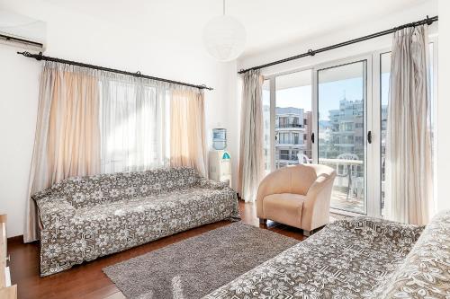 a bedroom with a bed and a chair and a window at Rix Palm Apartments in Kyrenia