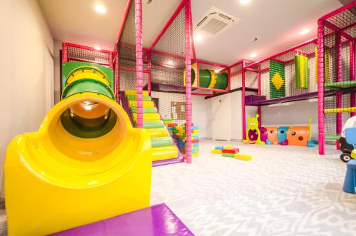 a play room with a yellow slide in a play room at Diune Hotel by Zdrojowa in Kołobrzeg