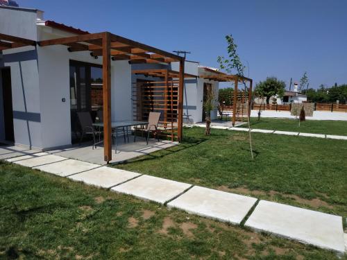 a patio with a table and chairs in a yard at Hill Sun Luxury Suites in Nea Iraklia