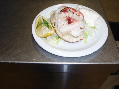 a plate of food with a fish and a lemon at The Old Forge Seafood Restaurant and Bed and Breakfast in Thursford
