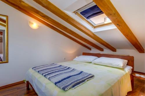 um quarto com uma cama e uma janela em apartman Nataša em Mali Lošinj