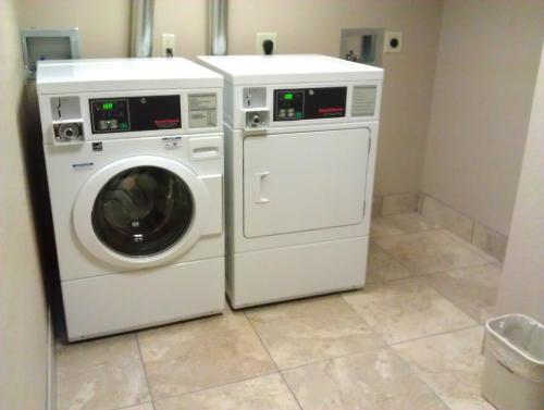 a washing machine and a washer in a bathroom at AmericInn by Wyndham Omaha in Omaha