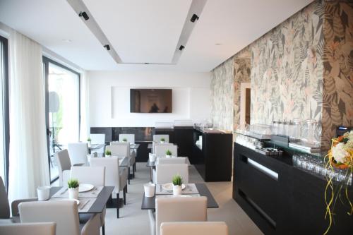 une salle à manger avec des tables et des chaises blanches dans l'établissement Villa Pina, à Bari