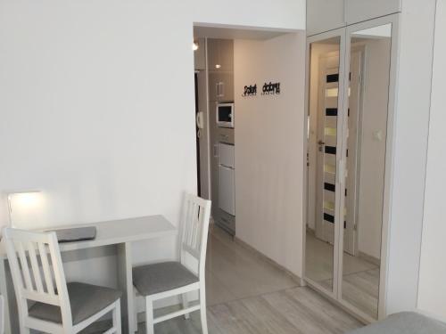 une salle à manger avec une table blanche et deux chaises dans l'établissement Apartament UnoPuro w centrum Giżycka, à Giżycko