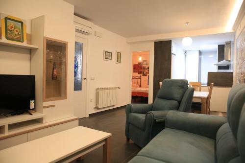 ein Wohnzimmer mit 2 Stühlen und einem TV in der Unterkunft APARTAMENTOS LA VEREDA in Cuenca