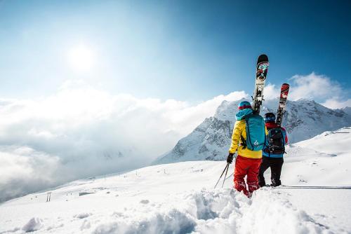 two people standing on top of a snow covered mountain with skis at Gasthaus Pension Montafonerhüsli in Sankt Gallenkirch