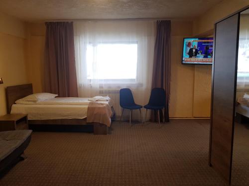 a hotel room with two beds and a television at Cabana Fulg De Nea Predeal in Predeal
