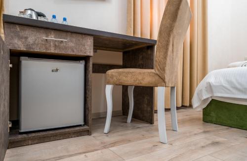 a desk with a chair next to a bed at Golden Light Hotel in Tbilisi City