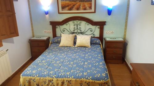 1 dormitorio con 1 cama azul y 2 mesitas de noche en Casas el Calar del Rio Mundo, en Riópar