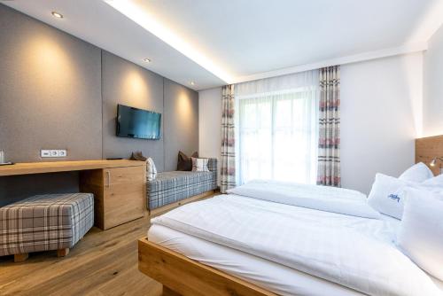 a hotel room with two beds and a television at B&B Appartement Das Stoaberg in Leogang