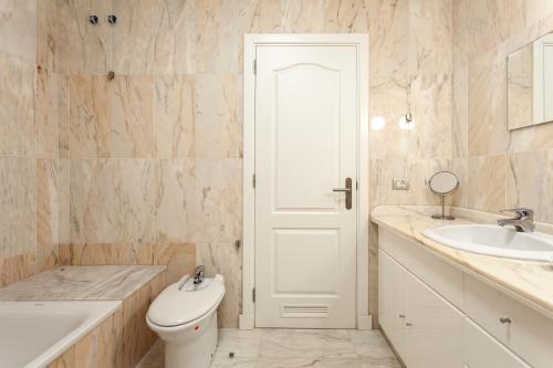 a white bathroom with a toilet and a sink at Apartamento Ocean View in Puerto de Santiago