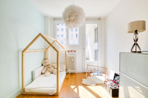 une chambre avec un berceau avec un ours en peluche dedans dans l'établissement Superbe Appart 3ch Terrasse Vue sur Lyon et garage, à Lyon