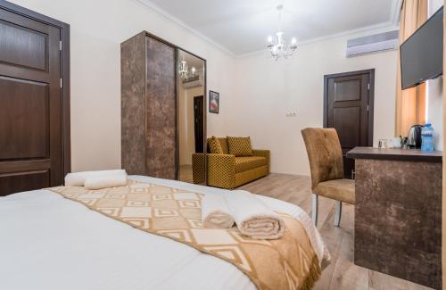 um quarto com uma cama, uma mesa e uma cadeira em Golden Light Hotel em Tbilisi