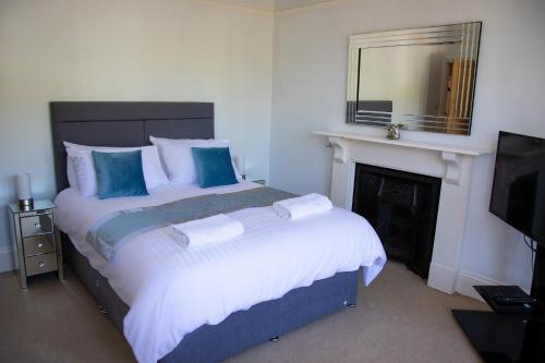 a bedroom with a bed with a fireplace and a mirror at Broadpark Villa in Ilfracombe