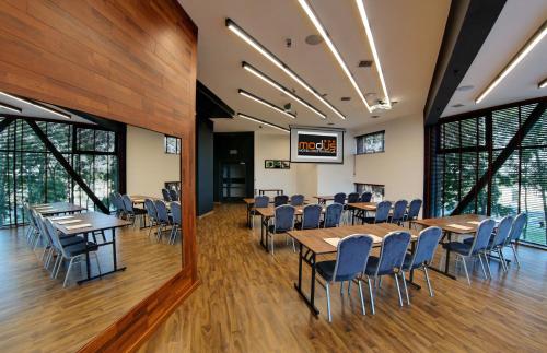 a conference room with tables and chairs and windows at Hotel Modus in Łaziska Górne