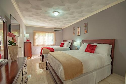 a bedroom with two beds and a television in it at Tropical Escape Villa in Ocho Rios