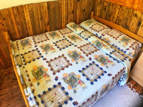 a bed with a quilt on it in a room at Kamp Vrbnica in Pluzine