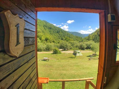 a door to a cabin with a view of a field at Kamp Vrbnica in Pluzine