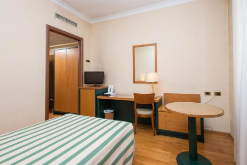 a hotel room with a bed and a desk and a table at Hotel San Francesco in Rende